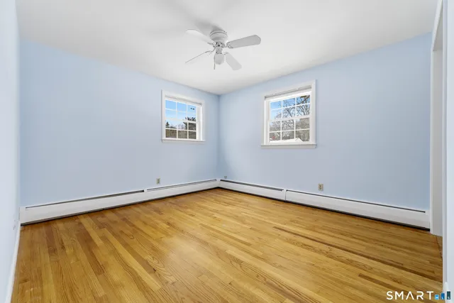 an empty room with a window and wooden floor