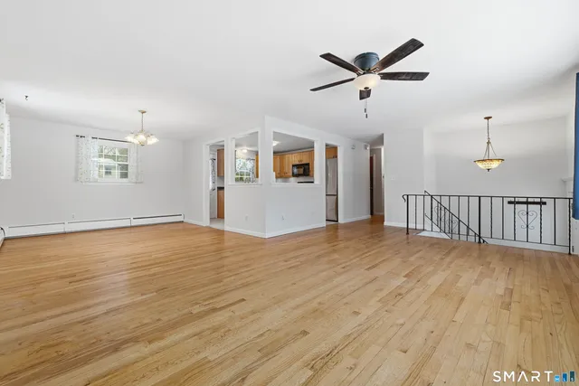 a view of a livingroom with a ceiling fan and wooden floor