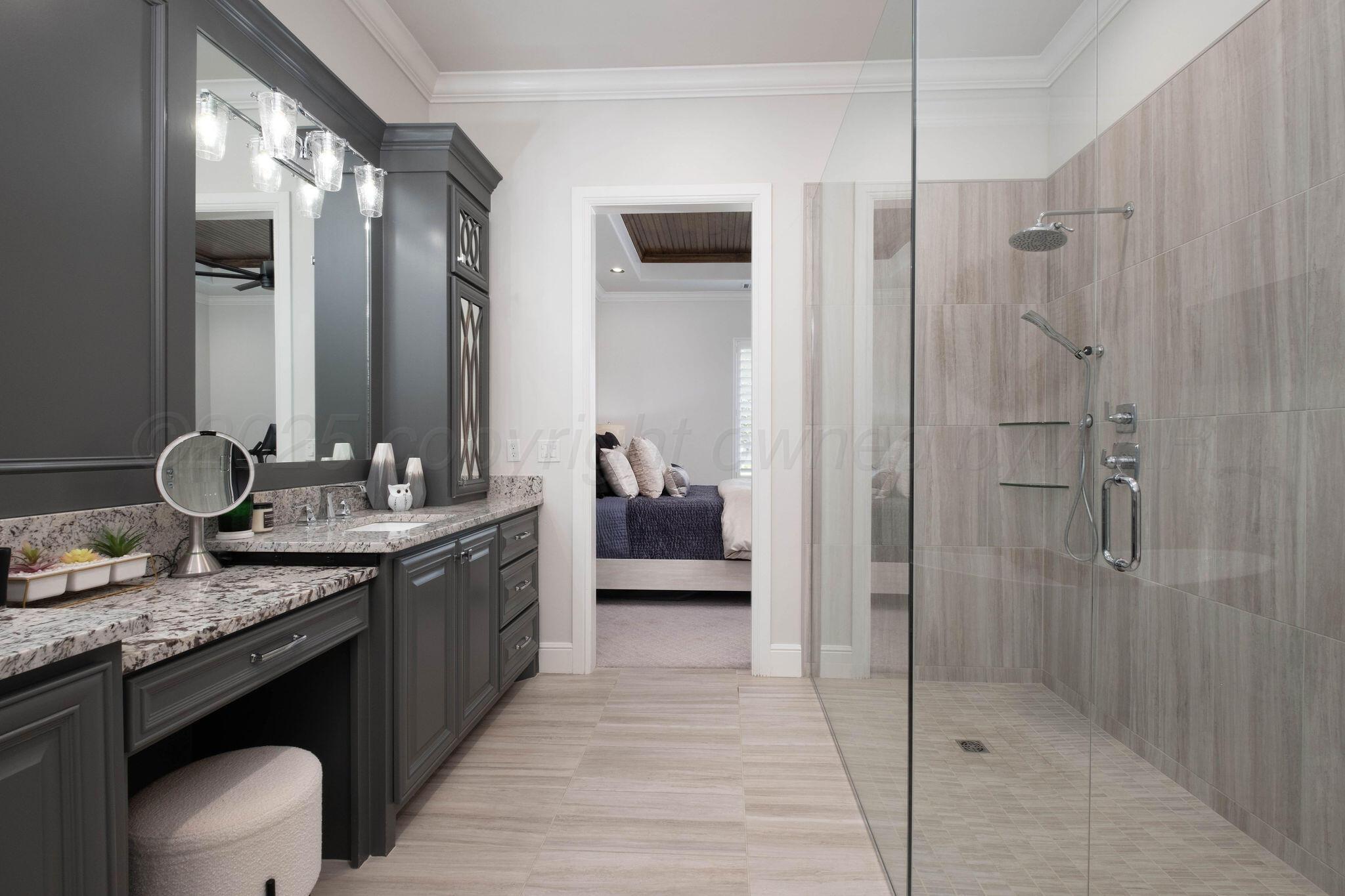 6103 Foley Square Street Amarillo, TX 79119 - Photo 28 of 52 a en suite bathroom with a granite countertop sink mirror and shower