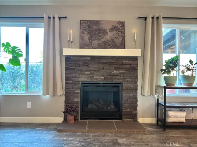 a living room with a fireplace and a floor to ceiling window