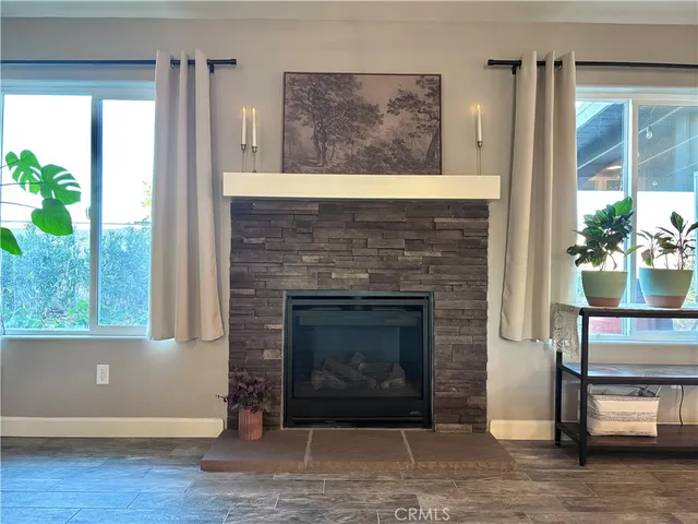 a living room with a fireplace and a floor to ceiling window