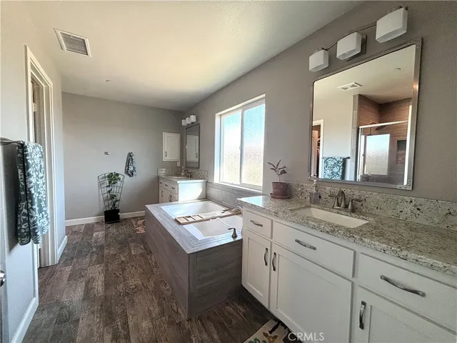 a spacious bathroom with a granite countertop sink and a mirror