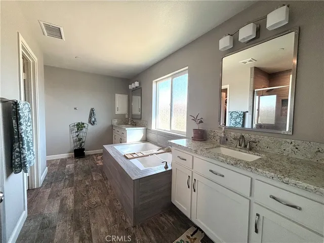 a spacious bathroom with a granite countertop sink and a mirror