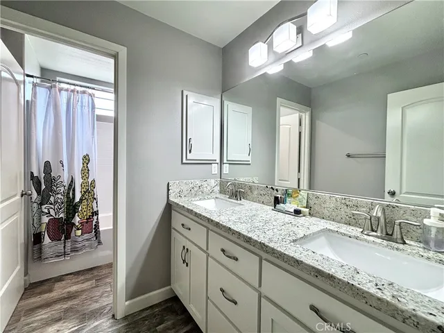 a bathroom with a granite countertop sink a large mirror and a shower