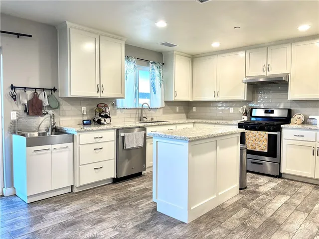 a kitchen with cabinets appliances a sink and a counter top space