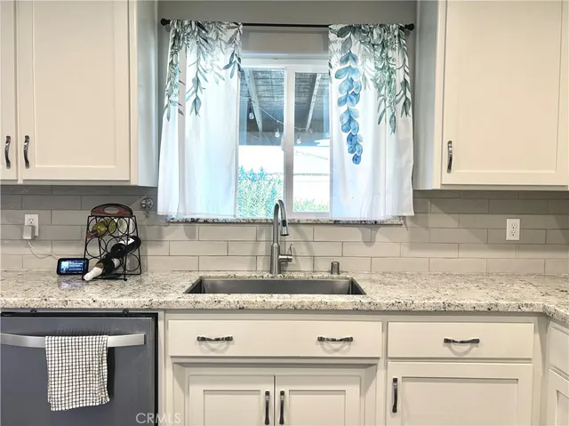 a kitchen with granite countertop a sink and a window