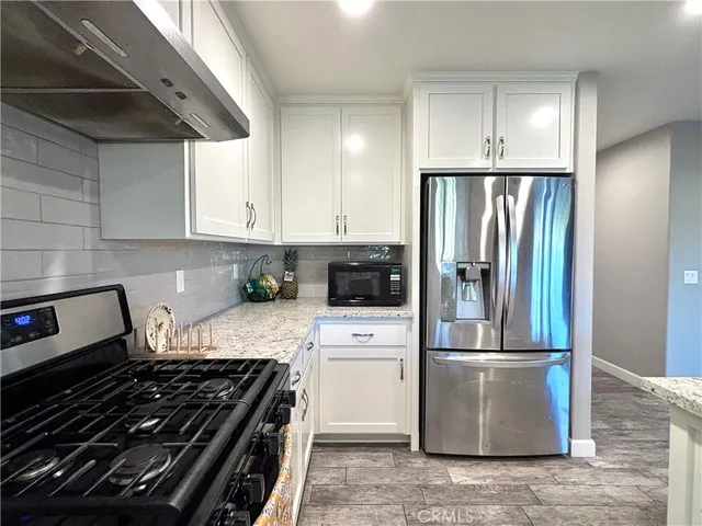 a kitchen with a stove a refrigerator and cabinets