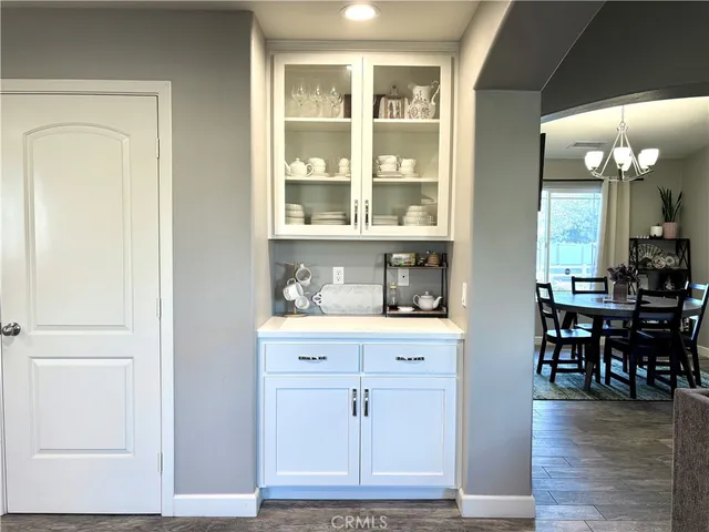 a room with wooden floor and white cabinets