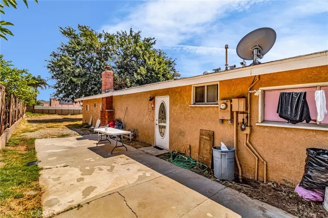 a backyard of a house with barbeque oven table and chairs