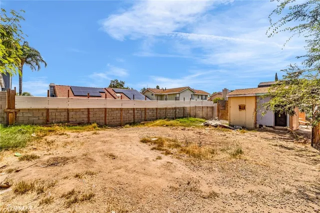 a view of a house with a yard and large tree