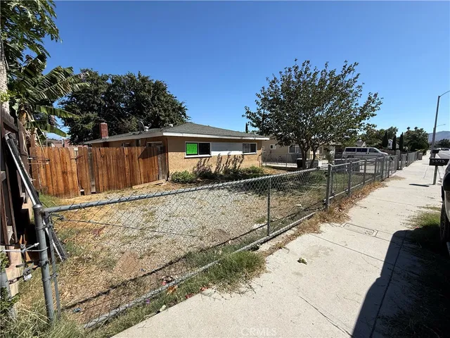 a view of a backyard with wooden fence