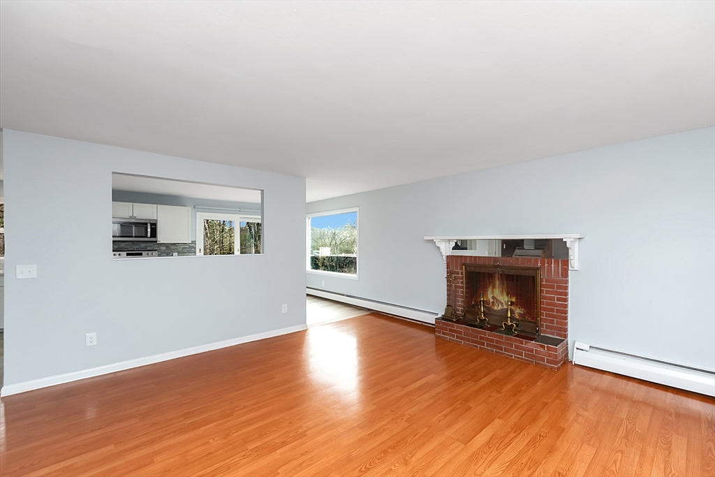 164 Sterling Road Lancaster, MA 01523 - Photo 12 of 36 a view of an empty room with wooden floor fireplace and a window