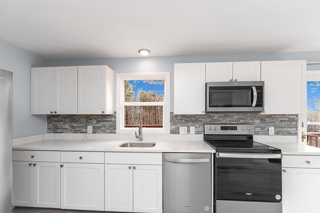 164 Sterling Road Lancaster, MA 01523 - Photo 5 of 36 a kitchen with stainless steel appliances a stove microwave and sink