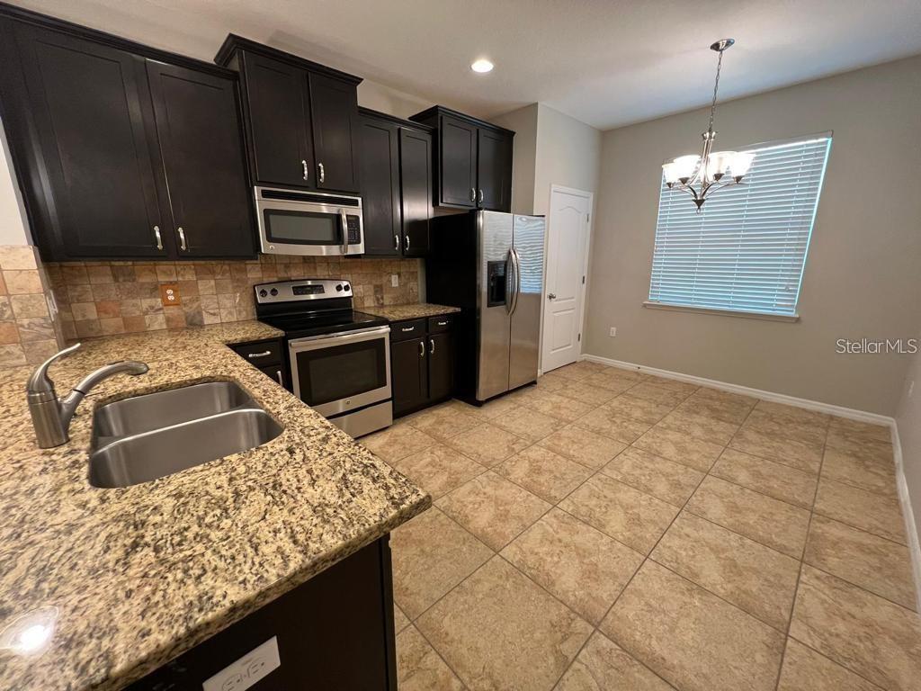 8301 Pine River Road Tampa, FL 33637 - Photo 8 of 16 a kitchen with stainless steel appliances granite countertop a sink stove and refrigerator