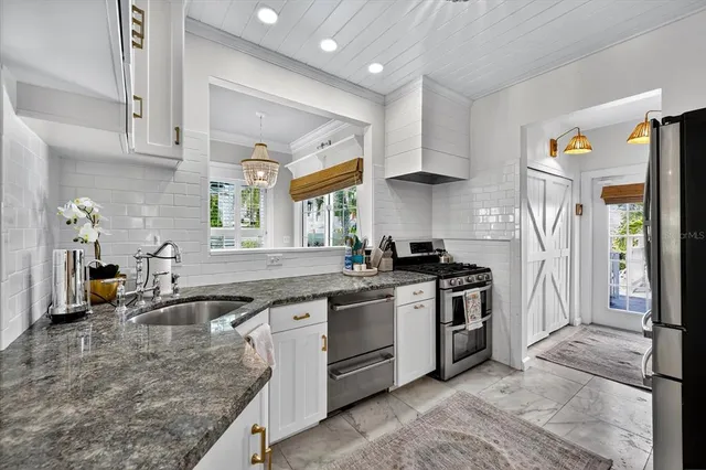a kitchen with granite countertop a sink a stove and cabinets