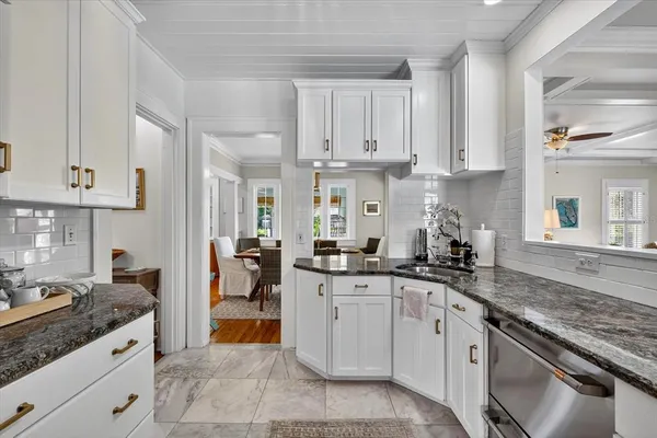 a bathroom with a granite countertop toilet a sink and a mirror