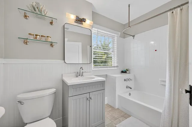 a kitchen with a refrigerator a stove a sink and white cabinets with wooden floor