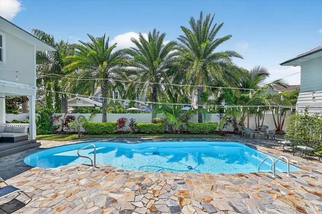 a living room with furniture floor to ceiling window and wooden floor
