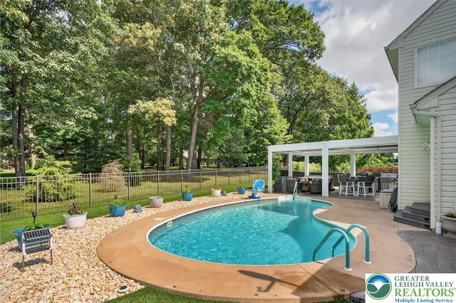 a kitchen with stainless steel appliances granite countertop a stove top oven a refrigerator a dining table and chairs with wooden floor