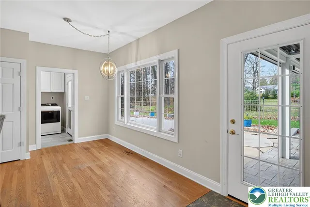 a view of hallway with window and wooden floor