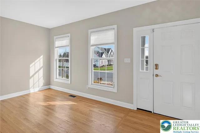 a view of a big room with wooden floor and windows