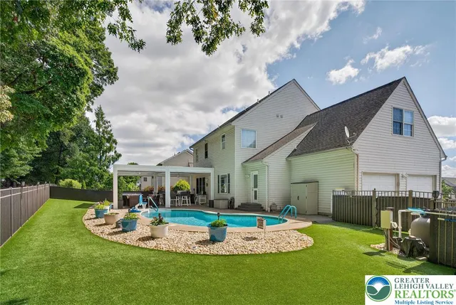 a view of a house with backyard sitting area and swimming pool