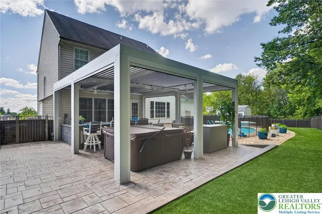 a view of a patio with table and chairs potted plants and floor to ceiling window