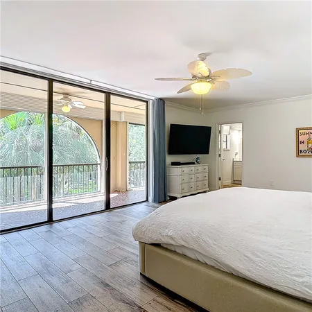 a spacious bedroom with a large bed and a flat tv screen on dresser