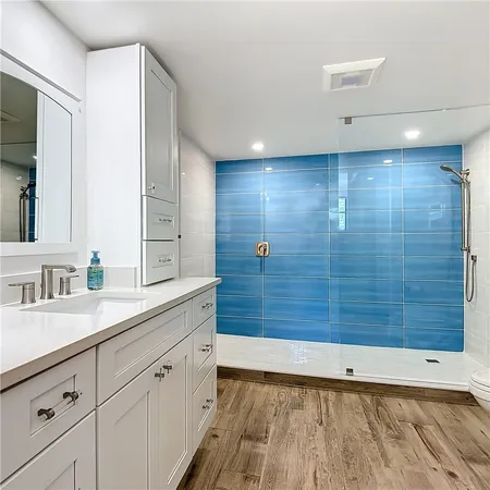 a bathroom with a granite countertop sink mirror and shower
