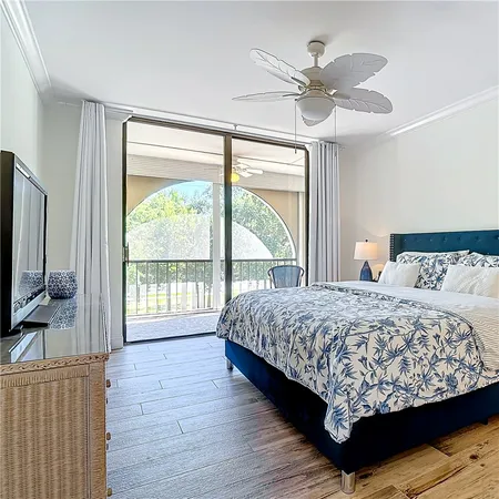 a bedroom with a large bed and a flat tv screen on dresser