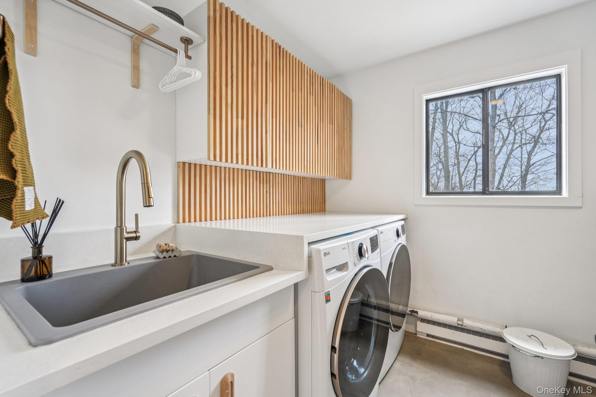 4 Mountain Brook Road Cornwall, NY 12518 - Photo 15 of 45 Custom laundry room with LG washer/dryer, Caesarstone countertop, and modern wood-slat cabinetry.
