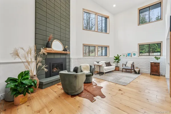 a living room with furniture a fireplace a potted plant and a window