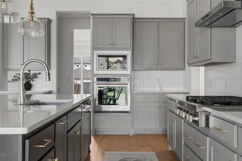 a kitchen with stainless steel appliances granite countertop a sink stove and cabinets