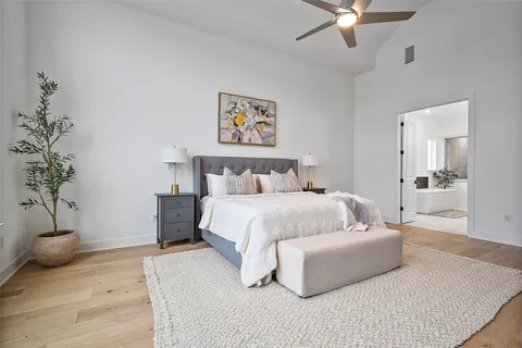 a bedroom with a large bed and a potted plant
