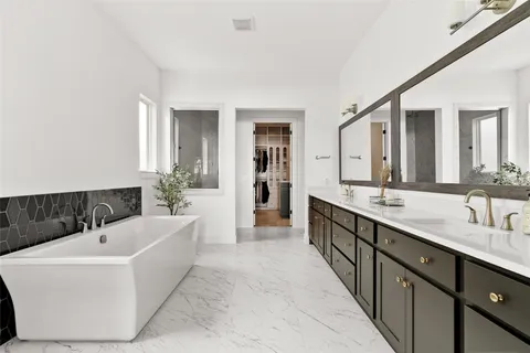 a spacious bathroom with a large tub sink and mirror