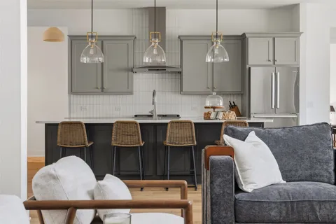 a living room with stainless steel appliances kitchen island granite countertop furniture and a view of kitchen