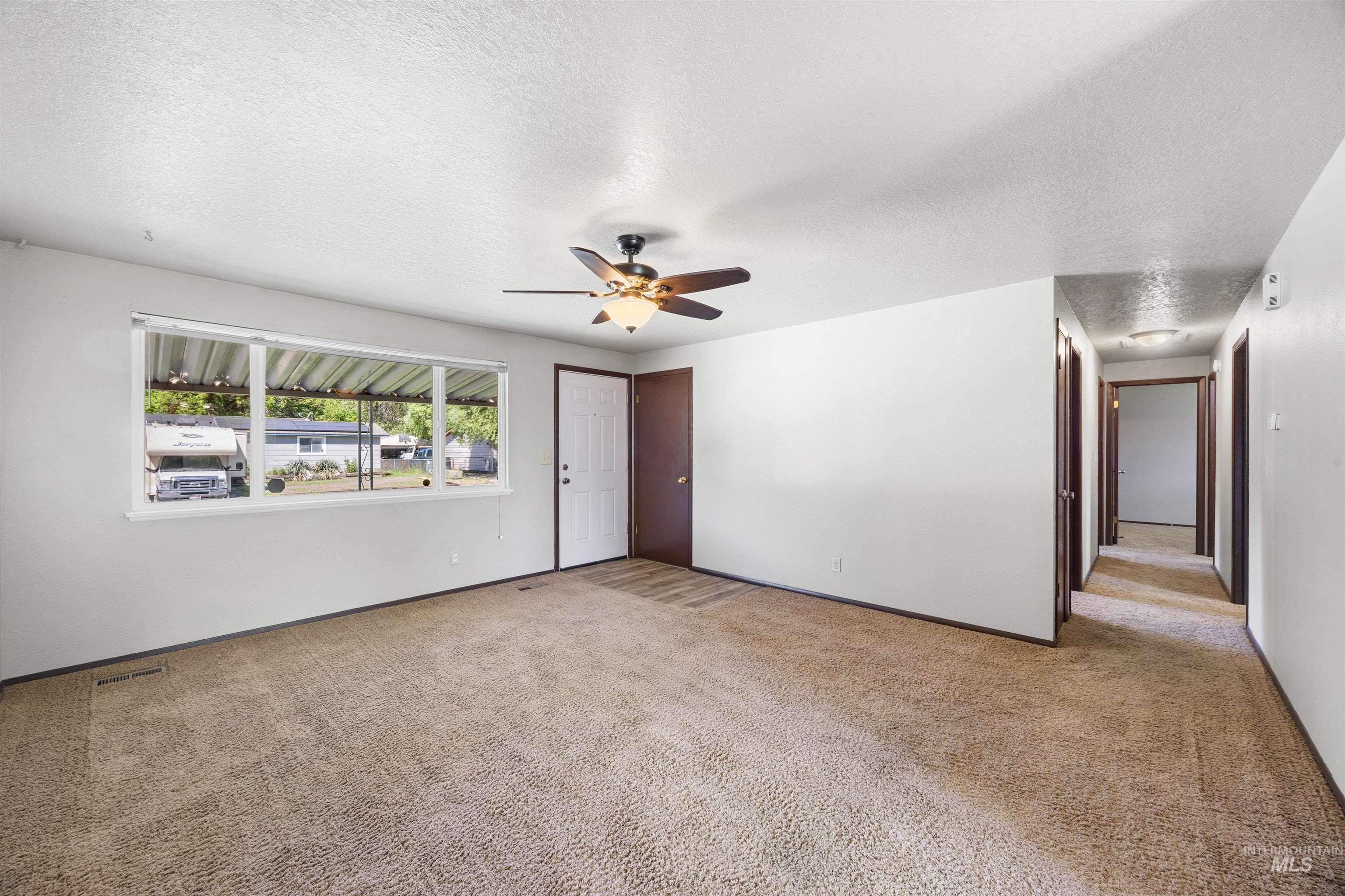 9 Villa Drive Middleton, ID 83644 - Photo 12 of 33 Living area featuring light-colored walls and brown-toned carpeting