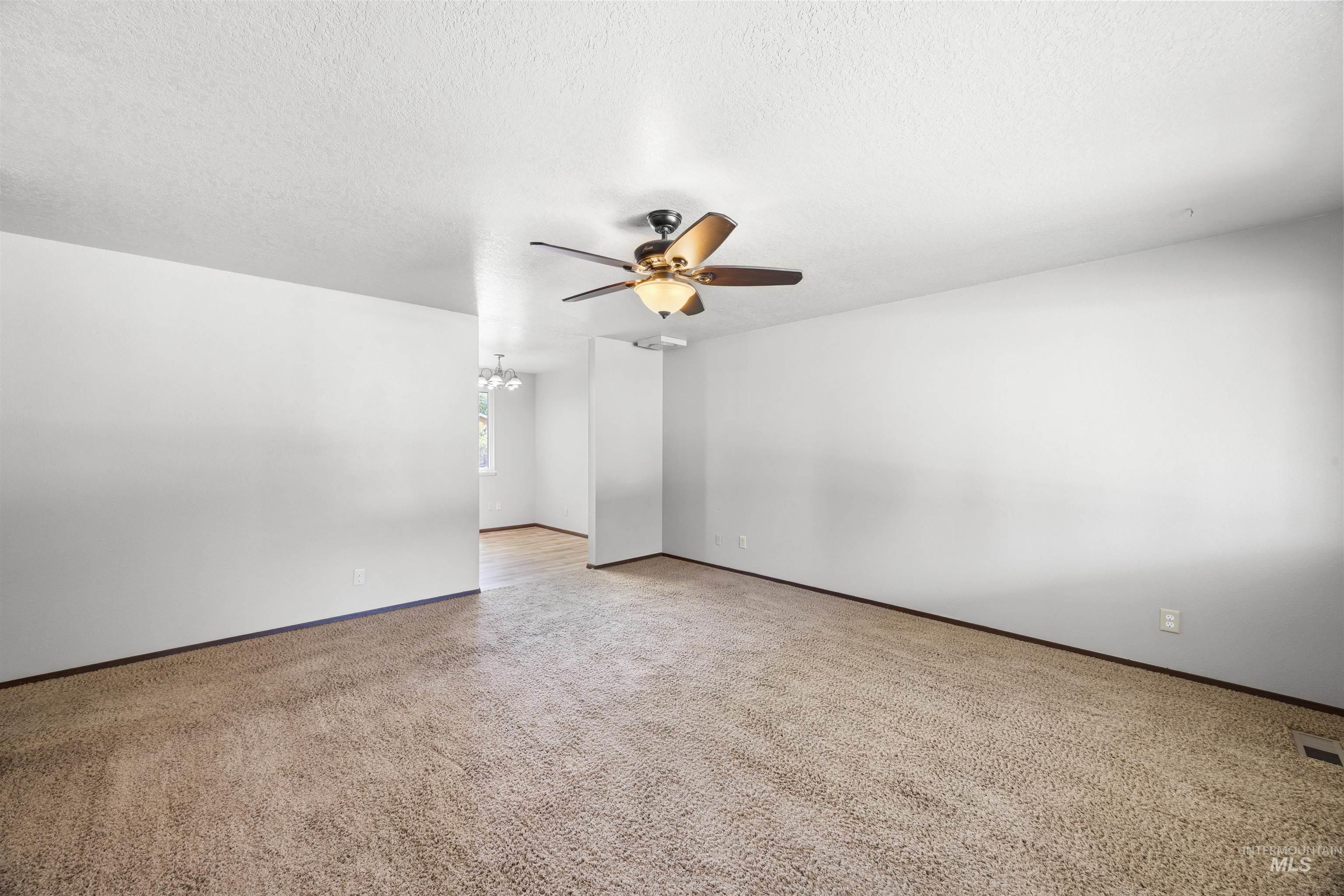9 Villa Drive Middleton, ID 83644 - Photo 13 of 33 Spacious room featuring textured carpet flooring, white walls, and a ceiling fan with integrated lighting