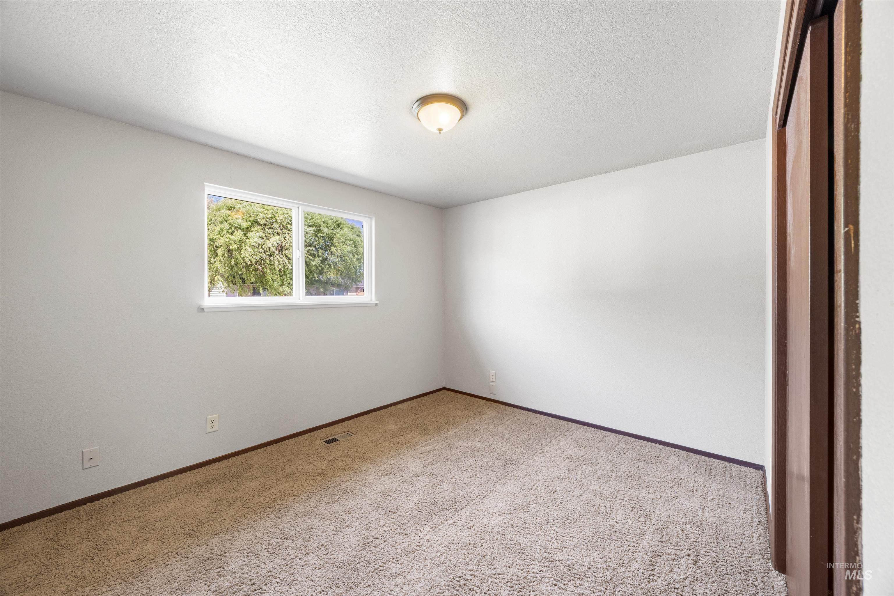 9 Villa Drive Middleton, ID 83644 - Photo 14 of 33 Carpeted bedroom featuring a double window, white walls, and a ceiling-mounted light fixture