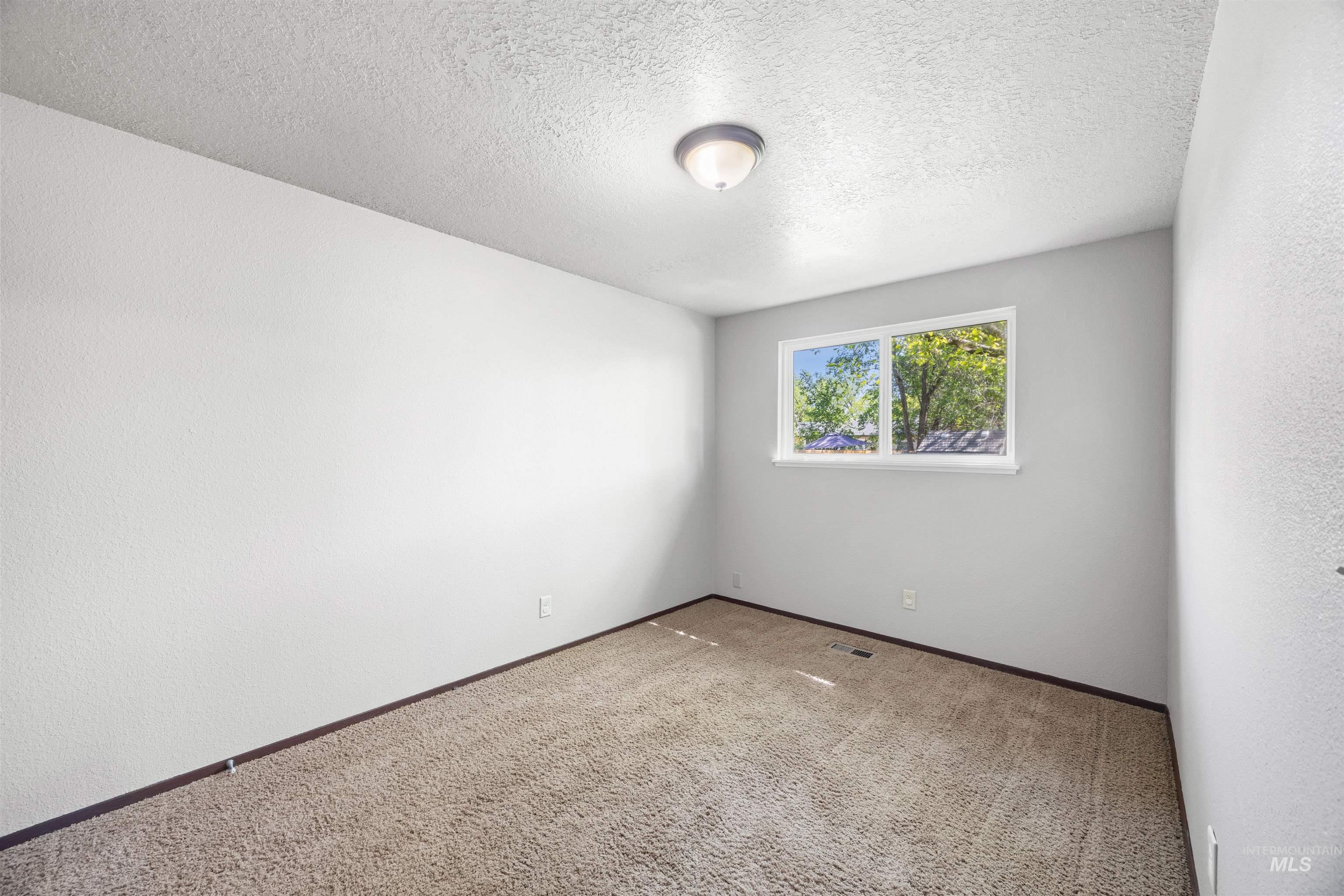 9 Villa Drive Middleton, ID 83644 - Photo 15 of 33 Carpeted bedroom featuring a single window, a ceiling-mounted light fixture, light-toned walls, and dark baseboards