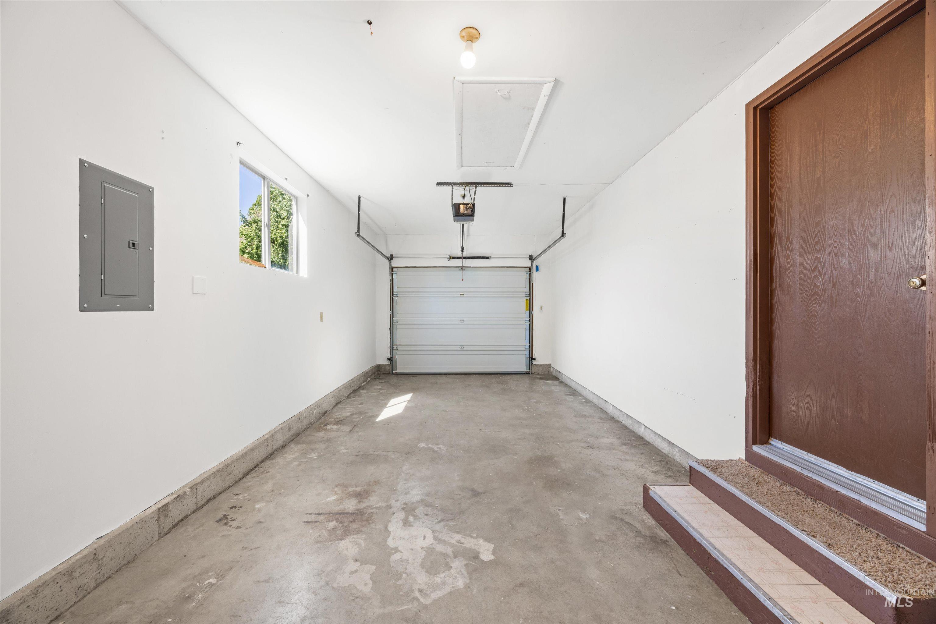 9 Villa Drive Middleton, ID 83644 - Photo 22 of 33 Single-car garage with a concrete floor, white walls, and an overhead garage door