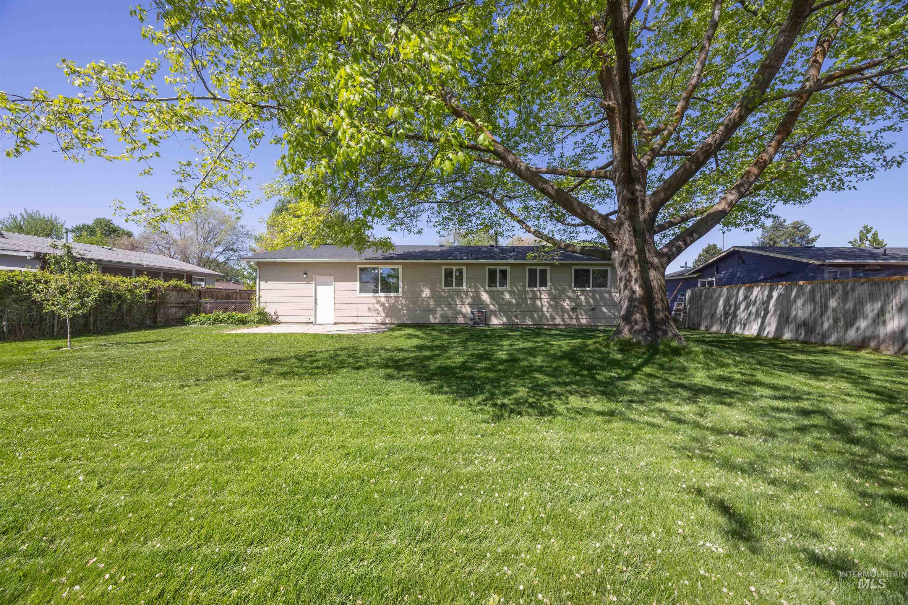 9 Villa Drive Middleton, ID 83644 - Photo 24 of 33 Spacious backyard featuring an established shade tree, a broad expanse of green lawn, and a concrete patio