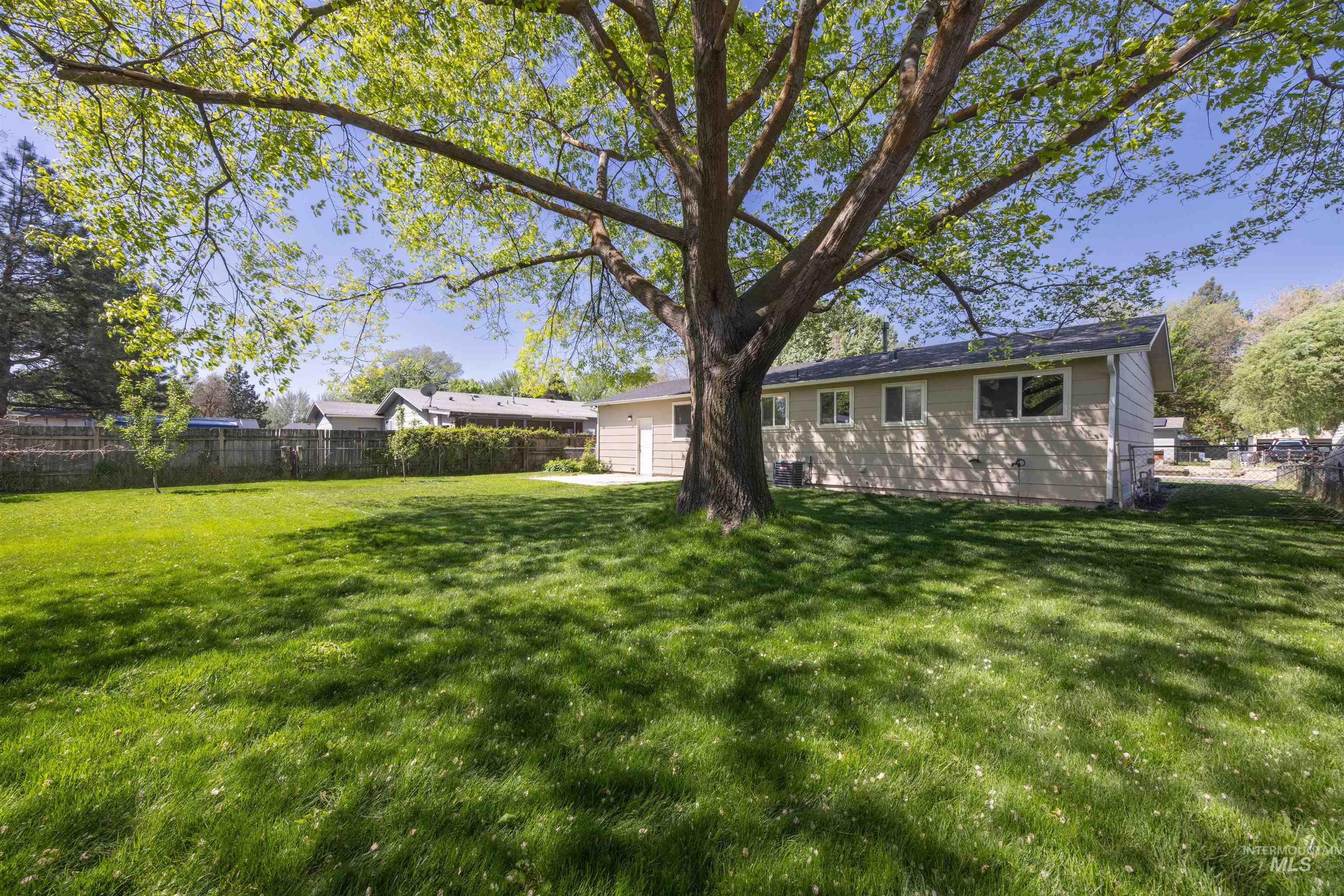 9 Villa Drive Middleton, ID 83644 - Photo 26 of 33 Expansive backyard featuring a large deciduous tree, broad lawn, and a perimeter fence