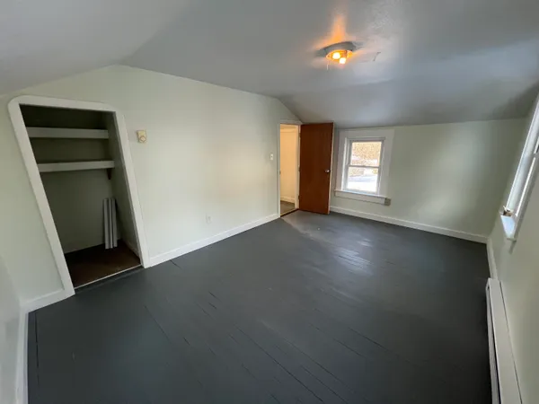 an empty room with windows and closet