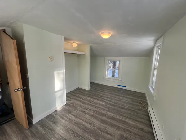 an empty room with wooden floor and a window