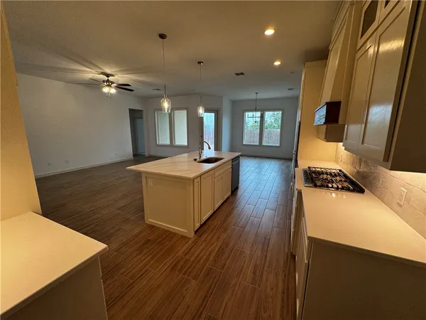 a living room with stainless steel appliances granite countertop furniture wooden floor and a view of kitchen