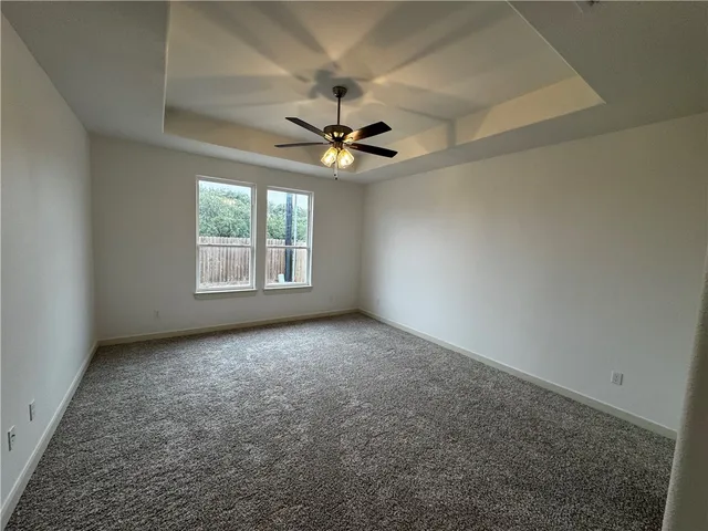 an empty room with windows and ceiling fan