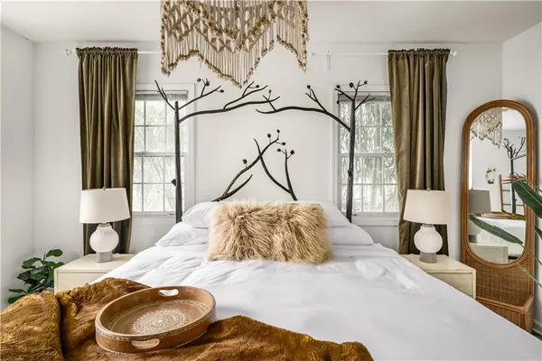 a bedroom with a bed and dresser with mirror