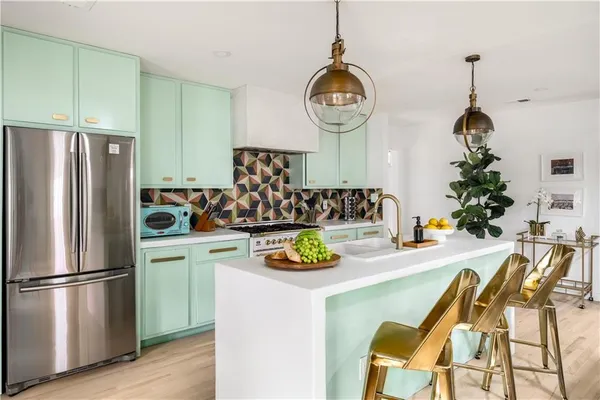 a kitchen with stainless steel appliances granite countertop a sink a refrigerator and a stove