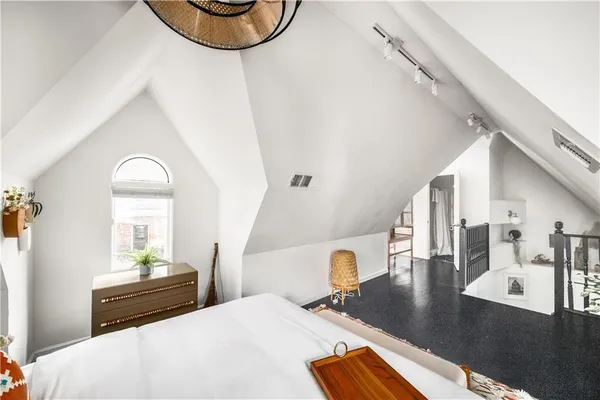 a bedroom with a bed and a lamp on dresser